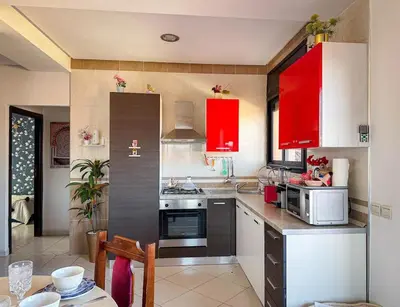 a kitchen with red cabinets and a stove top oven at Amazing Apartment Center city in Marrakech