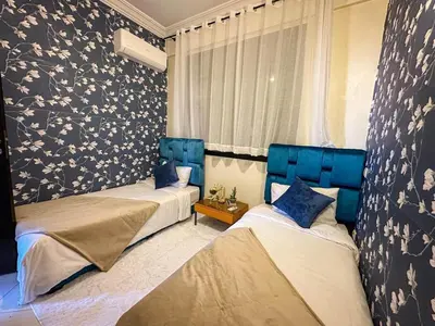 a bedroom with two beds with blue headboards at Amazing Apartment Center city in Marrakech