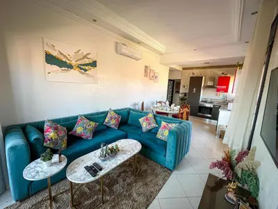 a living room with a blue couch and two tables at Amazing Apartment Center city in Marrakech