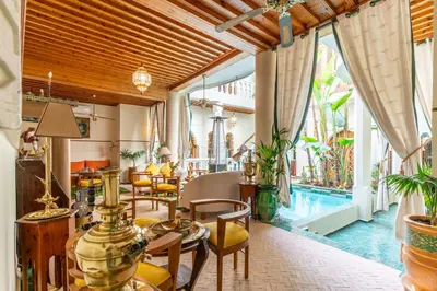 a living room with a table and chairs and a pool at Riad Habouba in Marrakech