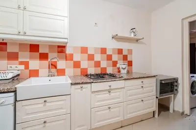 a kitchen with white cabinets and orange and white tiles at Golden Palm 2 in Marrakech