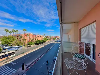 a balcony with a chair and a view of a street at Atrani1 happy holiday in Marrakech