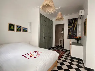 a bedroom with a white bed with flowers on it at Dar Nook in Marrakech