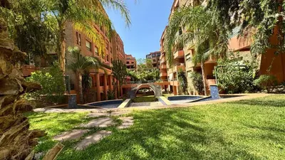 a park with a bench and some trees and buildings at Mms in Marrakech