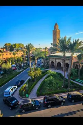 a group of cars parked on a street with a building at Raid lkaram in Marrakech