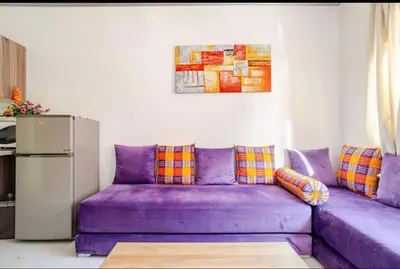 a purple couch in a living room with a refrigerator at Confort et style en pleins centre ville in Marrakech