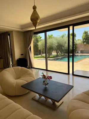 a living room with a couch and a table and a pool at Villa Famous 4 chambres in Marrakech