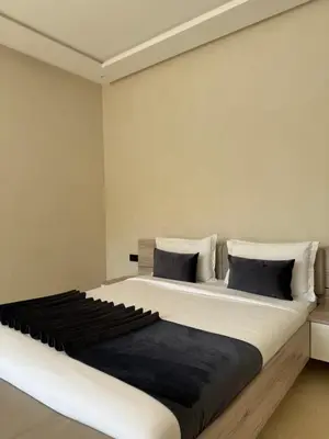 a bedroom with a large bed with black and white pillows at Villa Famous 4 chambres in Marrakech