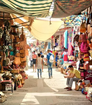 a group of people walking through a market at Appartement raffiné avec piscine au centre ville in Marrakech