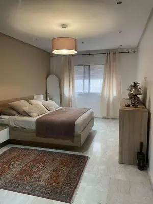 a bedroom with a large bed and a rug at Appartement ZAHRA HOME in Marrakech