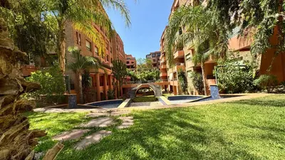 a park with a bench and palm trees and buildings at Modern apartment in City center in Marrakech