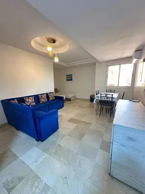 a living room with a blue couch and a table at Family apartment 22 in Marrakech