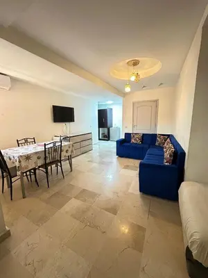 a living room with a blue couch and a table at Family apartment 22 in Marrakech