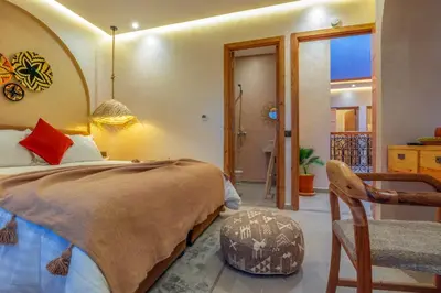 a bedroom with a large bed and a chair at ALKHAYMA Medina in Marrakech