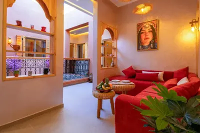 a living room with a red couch and a table at ALKHAYMA Medina in Marrakech
