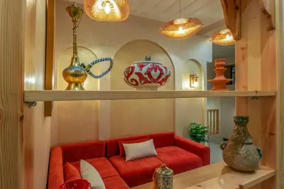 a living room with a red couch and shelves at ALKHAYMA Medina in Marrakech