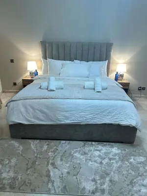 a large bed in a bedroom with two lamps at 2-bedroom luxury contemporary apartment Hivernage in Marrakech
