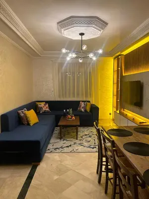 a living room with a blue couch and a table at 2-bedroom luxury contemporary apartment Hivernage in Marrakech