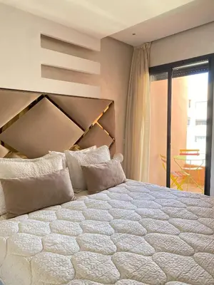 a bedroom with a large white bed with a large headboard at Appartement cosy à Marrakech in Marrakech
