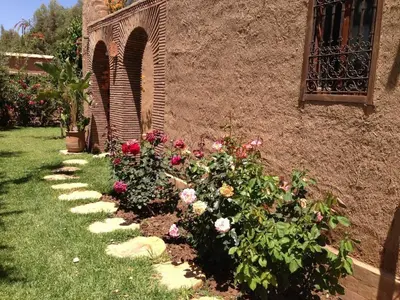 a garden of flowers next to a building at DAR TITRIT Charming house with garden and pool in Akhatar