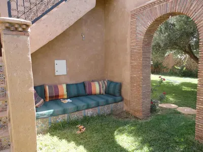 a blue couch sitting in the grass in a backyard at DAR TITRIT Charming house with garden and pool in Akhatar