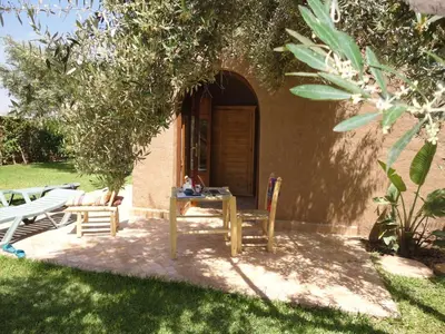 a table and chairs in front of a house at DAR TITRIT Charming house with garden and pool in Akhatar