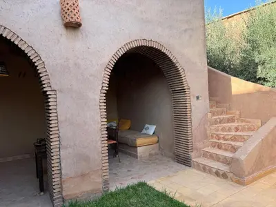 a stone archway with a bench in a patio at DAR EL KERMA Traditional Rustic House in Châba