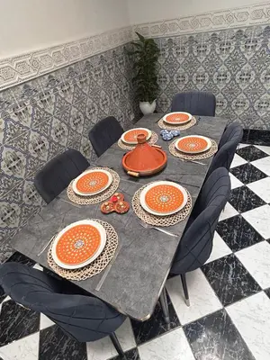 a dining table with orange plates and a teapot on it at Riad abdel in Marrakech