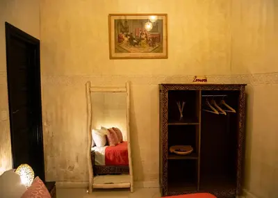 a room with a mirror and a bed and a painting at RIAD Dar ZOMOROD in Marrakech