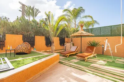 a patio with two chairs and an umbrella at Your Haven of Peace with Private Jacuzzi in Marrakech