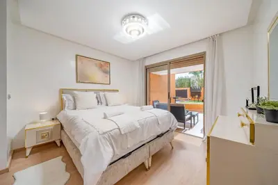 a bedroom with a large bed and a balcony at Your Haven of Peace with Private Jacuzzi in Marrakech