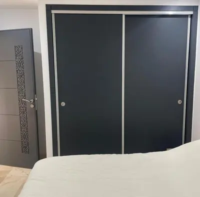 a bedroom with two black doors and a bed at Appartement 1 chambre - Superbe Terrasse & Vue Panoramique - Semlalia in Marrakech