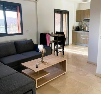 a living room with a couch and a table at Appartement 1 chambre - Superbe Terrasse & Vue Panoramique - Semlalia in Marrakech