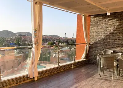 a balcony with a table and a large window at Appartement 1 chambre - Superbe Terrasse & Vue Panoramique - Semlalia in Marrakech