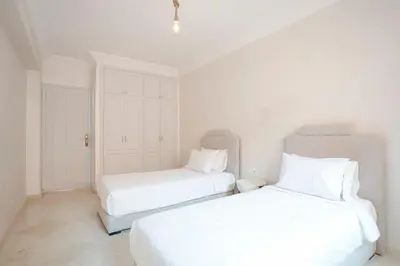 two beds in a white room with white walls at La Perle Blanche Gueliz in Marrakech