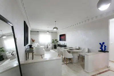 a white living room with a table and chairs at La Perle Blanche Gueliz in Marrakech