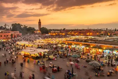 a crowd of people walking around a market at sunset at La Perle Blanche Gueliz in Marrakech