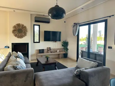 a living room with a couch and a tv at Villa avec piscine privée et sans vis à vis à Marrakech in Douar Nouaji