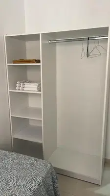 a white closet with shelves and a bed in a room at Appartement moderne rénové in Marrakech