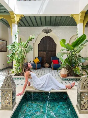 a woman laying on the edge of a swimming pool at Riad Kech One & Spa in Marrakech