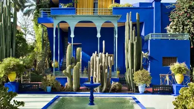 a blue building with cactuses and a fountain in front at A Stay To Remember - Marrakech Downtown in Marrakech