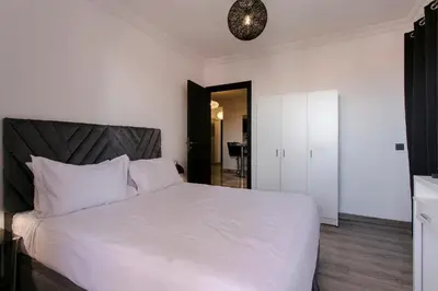 a bedroom with a white bed with a black headboard at A Stay To Remember - Marrakech Downtown in Marrakech