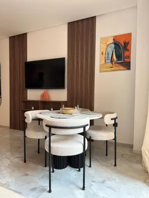 a dining room with a table and chairs at Appart haut standing - centre ville in Marrakech