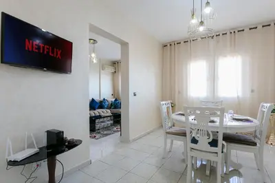 a kitchen and dining room with a table and chairs at Spacious Family Flat in Marrakech