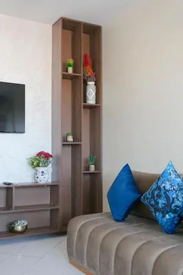 a living room with a couch and a shelf with plants at Spacious Family Flat in Marrakech