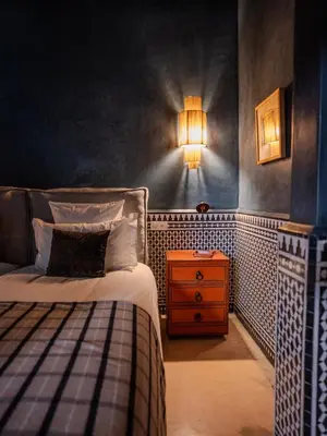 a bedroom with a bed and a nightstand and a lamp at Riad Mayan & Spa in Marrakech