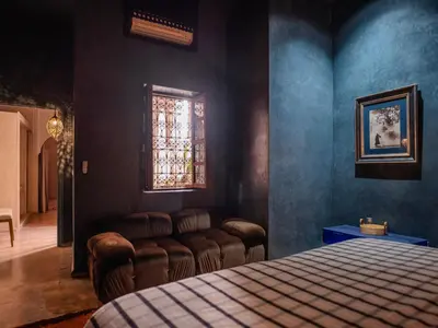 a bedroom with a bed and a couch and a window at Riad Mayan & Spa in Marrakech