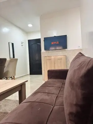 a living room with a couch and a tv on the wall at Beautiful Luxurious 2-bedroom with Wi-Fi Gueliz, Marrakech in Marrakech