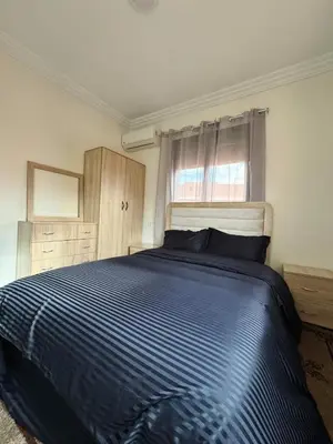 a bedroom with a bed with a blue comforter and a window at Beautiful Luxurious 2-bedroom with Wi-Fi Gueliz, Marrakech in Marrakech