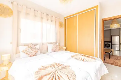 a bedroom with a white bed with a large window at Luxe et Calme de Guéliz avec Grande Terrasse in Marrakech